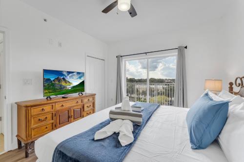 um quarto com uma cama grande e uma televisão em 2BR condo minutes to Disney Springs em Orlando