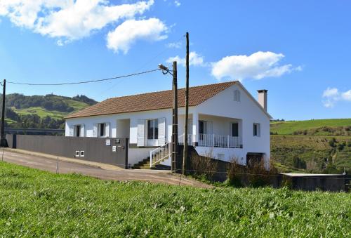 a white house on the side of a road at Costa's Guest House in Algarvia