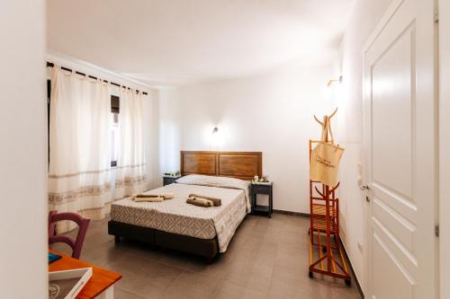 1 dormitorio con cama, mesa y escalera en Domo Mediterranea Affittacamere-Guest House, en SantʼAntìoco