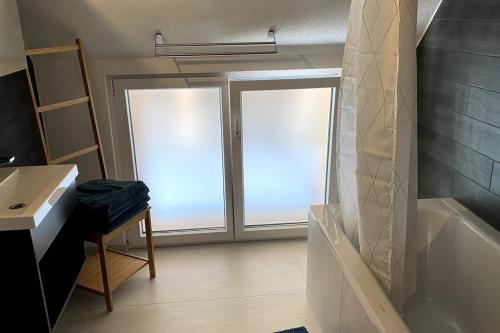 baño con ducha y bañera y ventana en triplex dans une ferme rénovée, en Gals