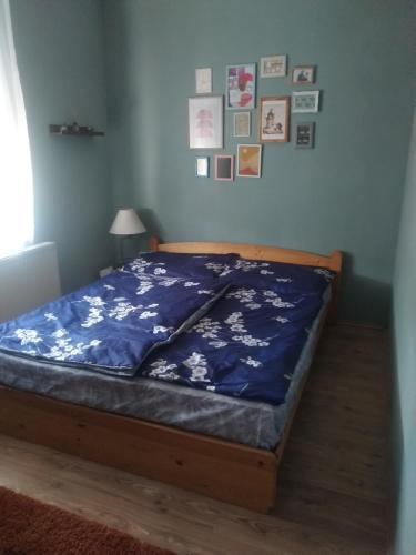 Una cama en un dormitorio con una manta azul. en Fejérvári Vendégház en Hajdúszoboszló