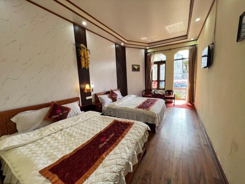a hotel room with two beds and a television at Lotus Hotel in Sapa