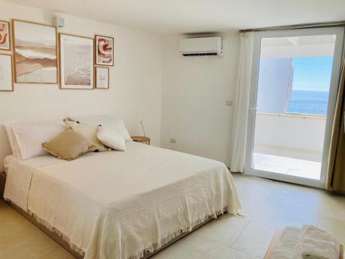 a bedroom with a bed with a view of the ocean at Puerto Escondido in Castro di Lecce