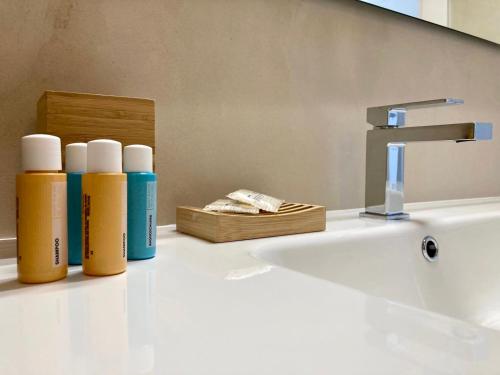 een badkamer met flessen geurstoffen naast een wastafel bij Puerto Escondido in Castro di Lecce