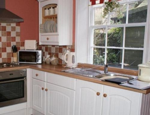 a kitchen with white cabinets and a counter top at Laverick Steps in Whitby