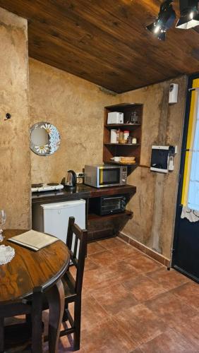 a kitchen with a table and a counter top at Posada del Santo Green & Rest - Cabañas in Salta