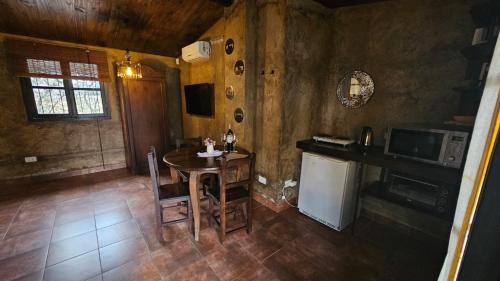 a kitchen with a table and a stove and a refrigerator at Posada del Santo Green & Rest - Cabañas in Salta