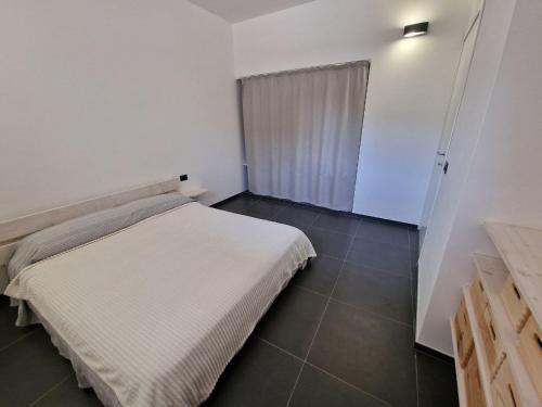 - une chambre avec un lit blanc et du carrelage dans l'établissement La casa della salemitana, à Pantelleria