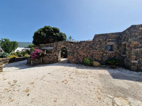 un bâtiment en briques avec une arche dans une cour dans l'établissement La casa della salemitana, à Pantelleria