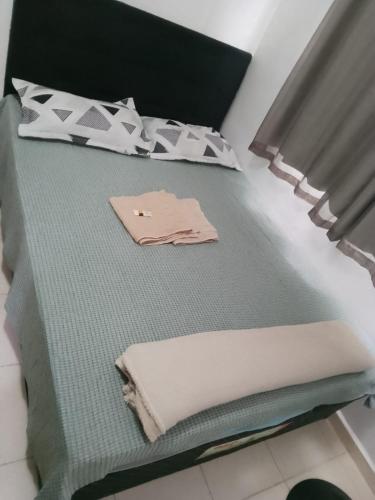 a bed in a room with a pillow and a towel at Apto Ruan Oni in Campos dos Goytacazes