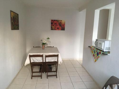a dining room with a table with a vase of flowers at Apto Ruan Oni in Campos dos Goytacazes