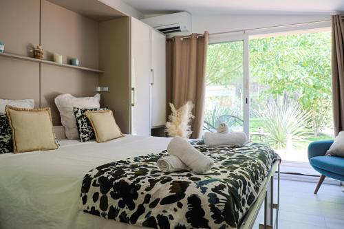 een slaapkamer met een bed en een groot raam bij LES LODGES TAIZEN, séjour SPA- sans enfants in Saint-Cannat