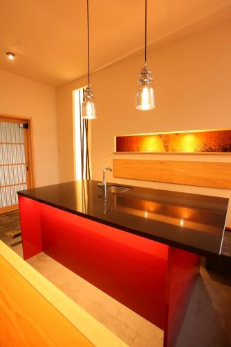 a kitchen with a black and red counter with lights at Sanjoubou Sansou villa in Kyoto