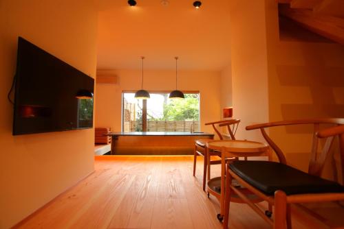 salon ze stołem i krzesłami oraz oknem w obiekcie Sanjoubou Sansou villa w mieście Kioto