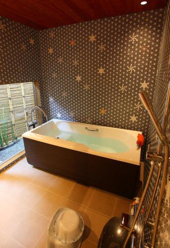 a bathroom with a large tub in a room at Sanjoubou Sansou villa in Kyoto