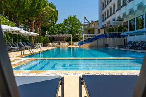 een zwembad met blauw water in een gebouw bij Cashmere Hotel in Kuşadası