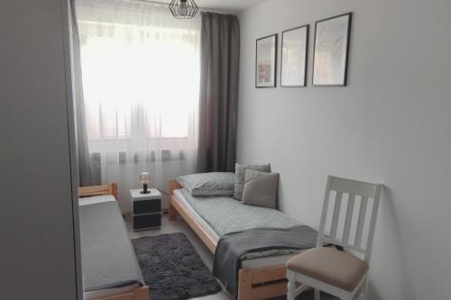 una piccola camera con letto e sedia di Apartament SARA a Kołobrzeg