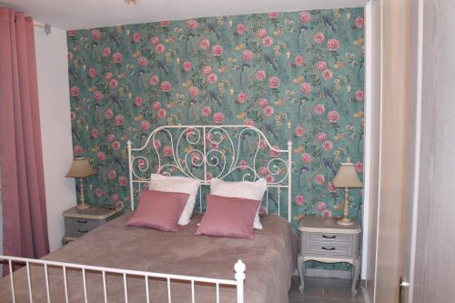 - une chambre avec un lit et un papier peint floral dans l'établissement Le bonheur au soleil, à Saint-Maximin-la-Sainte-Baume