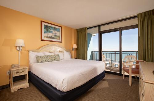 una habitación de hotel con una cama y un balcón en Grande Shores Ocean Resorts Condominiums, en Myrtle Beach