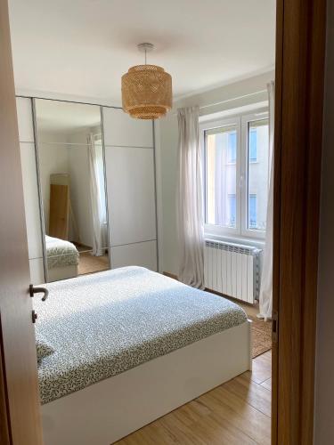 - une chambre avec un grand miroir et un lit dans l'établissement T3 Neuf, parking & garage privé, proche centre, à Sarlat-la-Canéda