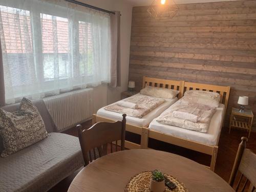 2 łóżka w pokoju ze stołem i kanapą w obiekcie Farma u Prokopů Humpolec w mieście Humpolec