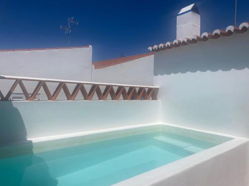 a swimming pool on the side of a white house at Casa Vó Briata in Mértola