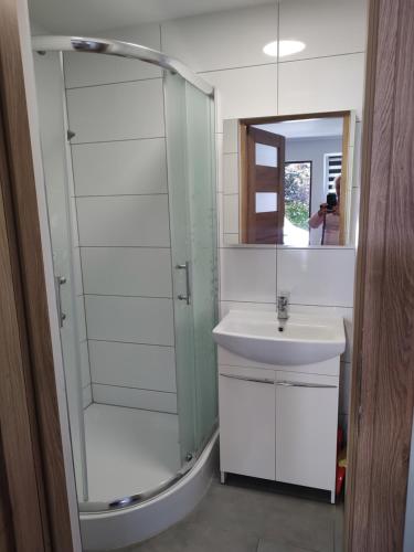 a bathroom with a shower and a sink and a mirror at Na Klifie in Jarosławiec