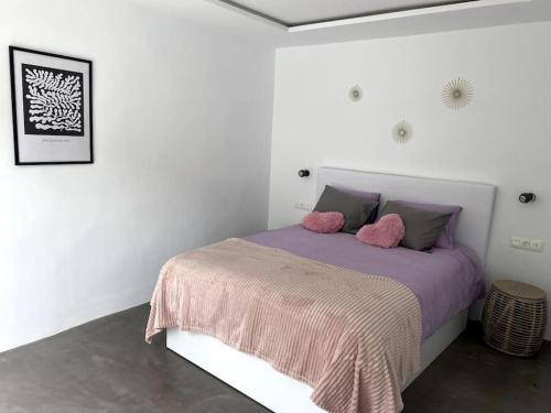 Habitación blanca con cama con almohadas rosas en Cosy finca, sea views, jacuzzi, en La Asomada