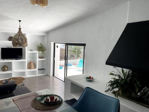 sala de estar con silla azul y mesa en Cosy finca, sea views, jacuzzi, en La Asomada