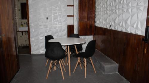 a table and four black chairs in a room at Suites Las Plazas in Cuernavaca