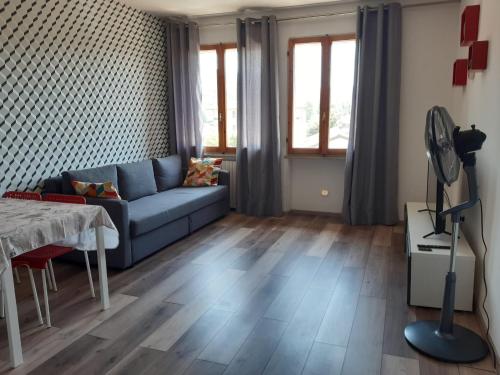 - un salon avec un canapé bleu et une table dans l'établissement Appartamento ristrutturato - Castrocaro Terme, à Castrocaro Terme