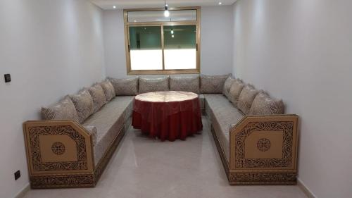 uma sala de estar com um sofá e uma mesa em Un coin de tranquillité en plein cœur de l'action em Al Hoceïma