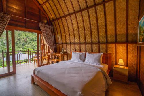 a bedroom with a bed in a room with windows at Lumbung Seraya Villa in Karangasem