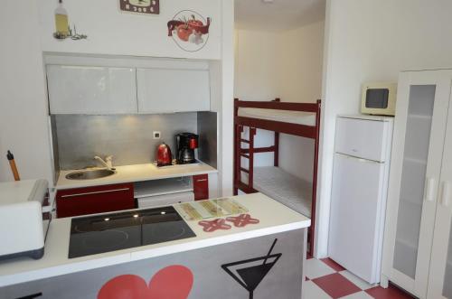 cocina pequeña con fregadero y fogones en Studio cabine + Parking : proche plage en Canet-en-Roussillon