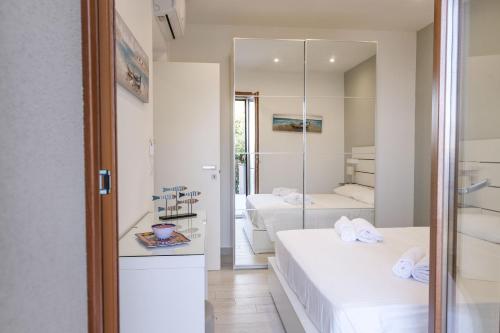 a hotel room with two beds and a mirror at Isola Bella Luxury View in Taormina