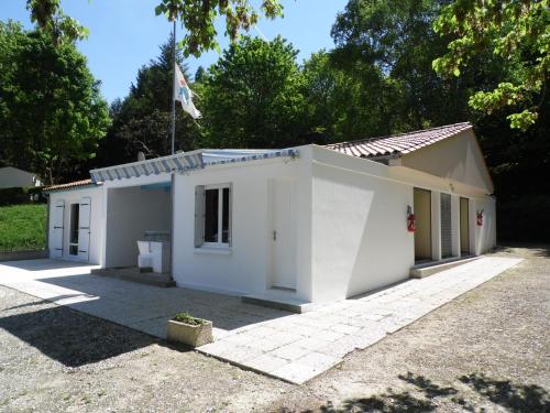 Un bâtiment blanc avec un drapeau en haut dans l'établissement Camping margot, à Archiac