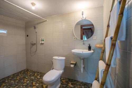 a bathroom with a toilet and a sink at Lumbung Seraya Villa in Karangasem