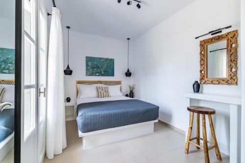 1 dormitorio con cama y espejo en Stafylos Green, en Skopelos Town