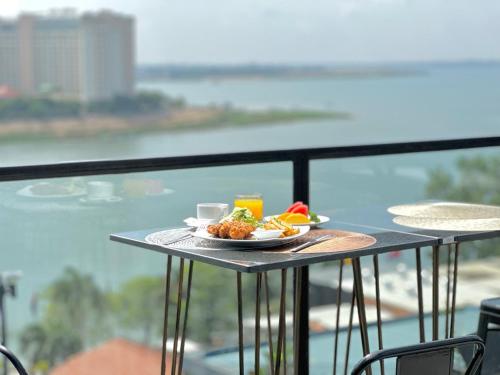 un piatto di cibo su un tavolo sul balcone di Harmony Phnom Penh Hotel a Phnom Penh