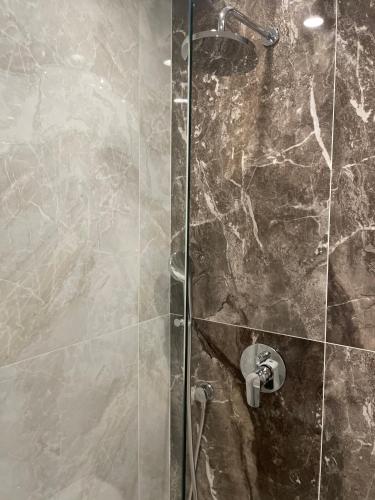 a shower with a glass door in a bathroom at Hotel AVENUE in Ravda