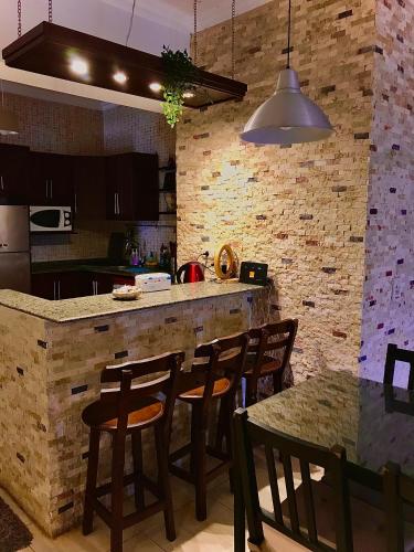 a kitchen with a bar with chairs and a table at Chalet Marina Wadi Degla Families Only Pool view 2nd floor with Roof 6 adults in Ain Sokhna