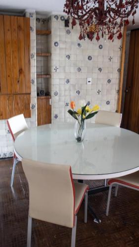 a white table with chairs and a vase of flowers on it at Suites Las Plazas in Cuernavaca
