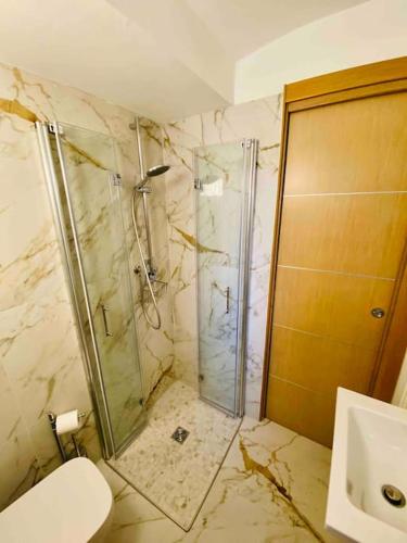 a bathroom with a glass shower and a toilet at Casa Macrino Apartment Alba in Alba