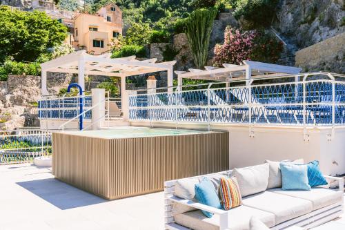 a patio with a white couch and blue fencing at Acquachiara Seaside Luxury Villa in Amalfi Coast in Maiori