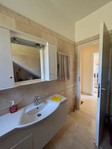 a bathroom with a sink and a mirror at MANI Kamares Beach House in Gythio