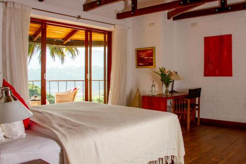 a bedroom with a bed and a table and a window at Bougainvillea Retreat in Kandy