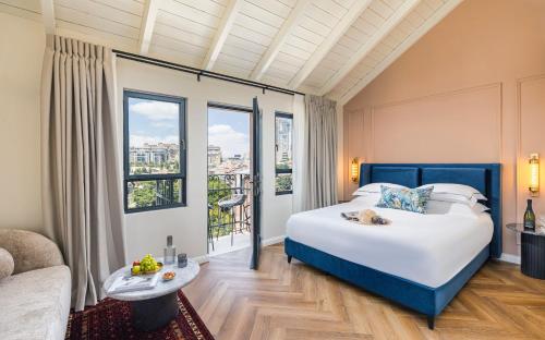 a bedroom with a bed and a large window at Damson - Machne Yehuda Hotel in Jerusalem