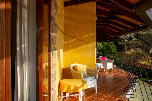 a porch with chairs and a yellow table at Bougainvillea Retreat in Kandy