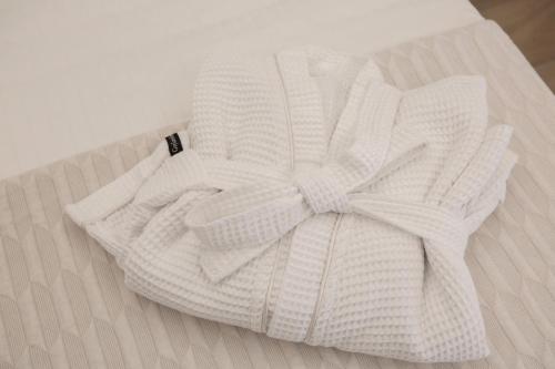 a white towel with a bow on top of a bed at ELFAM CITY SUITES in Lefkada