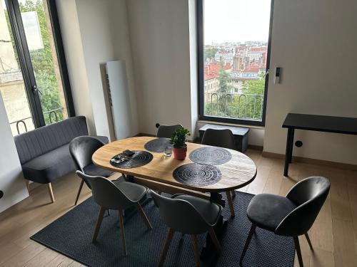einen Tisch und Stühle in einem Zimmer mit einem großen Fenster in der Unterkunft Superbe Duplex rénové avec vue exceptionnelle sur Lyon in Lyon